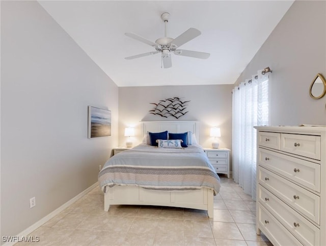 bedroom with a ceiling fan, lofted ceiling, baseboards, and light tile patterned floors