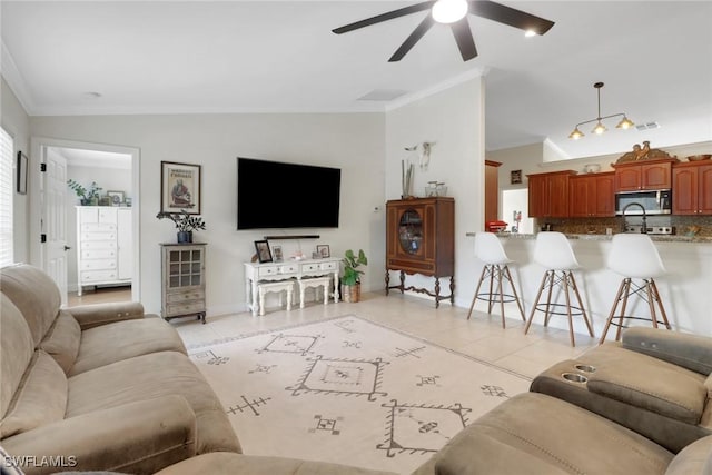 living room with light tile patterned floors, a ceiling fan, baseboards, vaulted ceiling, and ornamental molding