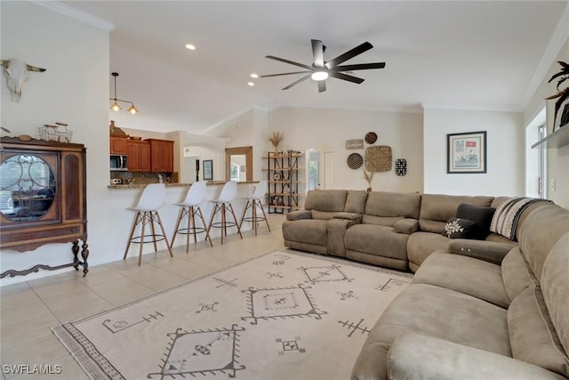 living room featuring ornamental molding, lofted ceiling, ceiling fan, and light tile patterned floors