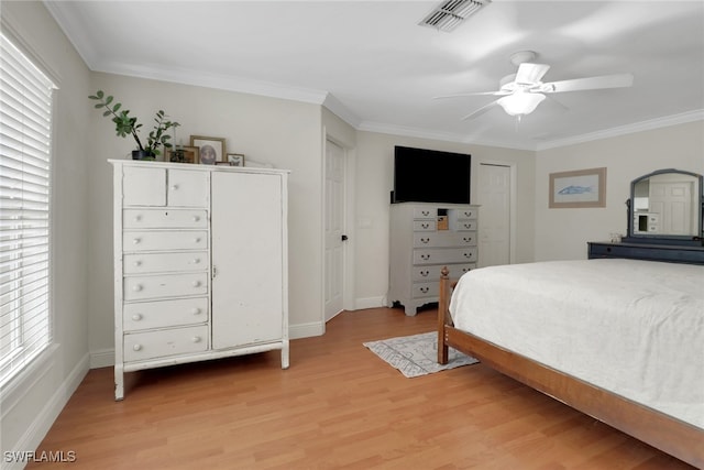 bedroom featuring light wood-style flooring, multiple windows, visible vents, and crown molding