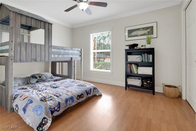 bedroom featuring ornamental molding, wood finished floors, a ceiling fan, and baseboards