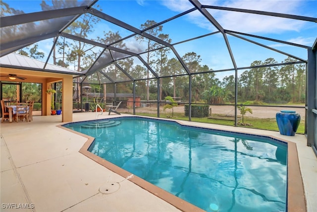 outdoor pool with glass enclosure and a patio area