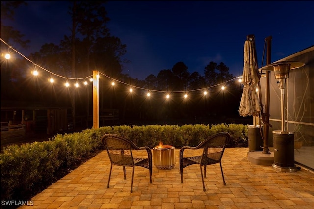 patio at night featuring an outdoor fire pit