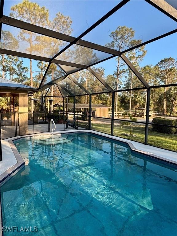 pool featuring a patio, fence, and a lanai