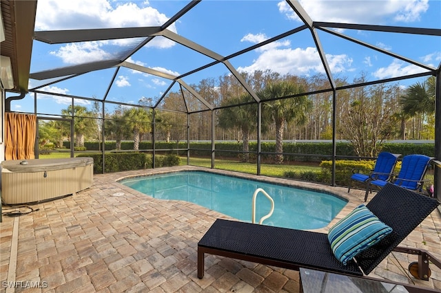 outdoor pool with a patio area, a hot tub, and glass enclosure