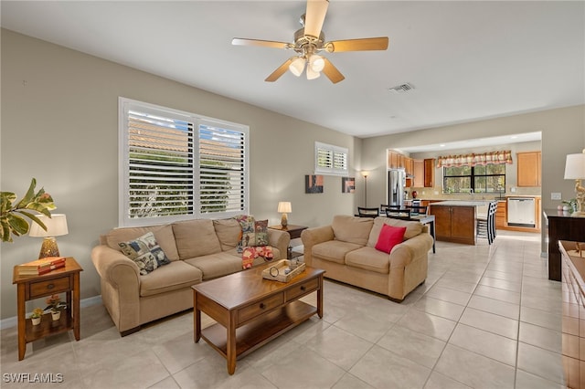 living area featuring light tile patterned floors, ceiling fan, and visible vents