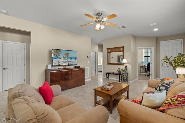 living area featuring ceiling fan, light tile patterned flooring, visible vents, and baseboards