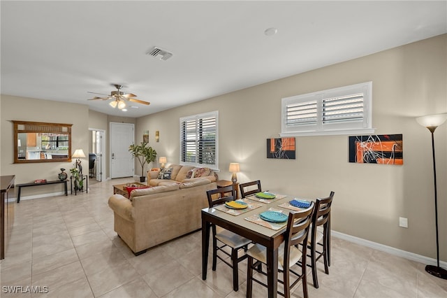 dining area featuring light tile patterned floors, a ceiling fan, visible vents, and baseboards