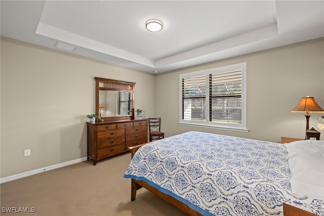 bedroom with carpet floors, a tray ceiling, visible vents, and baseboards