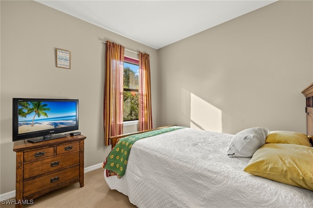 bedroom with light carpet and baseboards