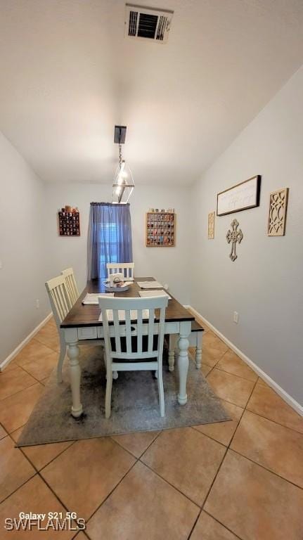 dining room with vaulted ceiling, tile patterned flooring, visible vents, and baseboards