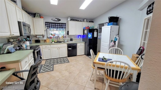 kitchen featuring light countertops, white cabinets, a sink, light tile patterned flooring, and black appliances