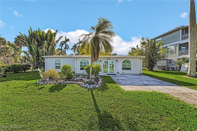 view of front facade featuring french doors, a front lawn, and stucco siding