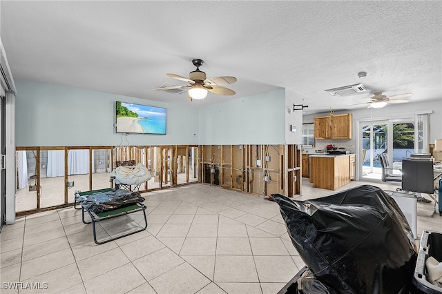 living area featuring visible vents, a textured ceiling, and light tile patterned flooring