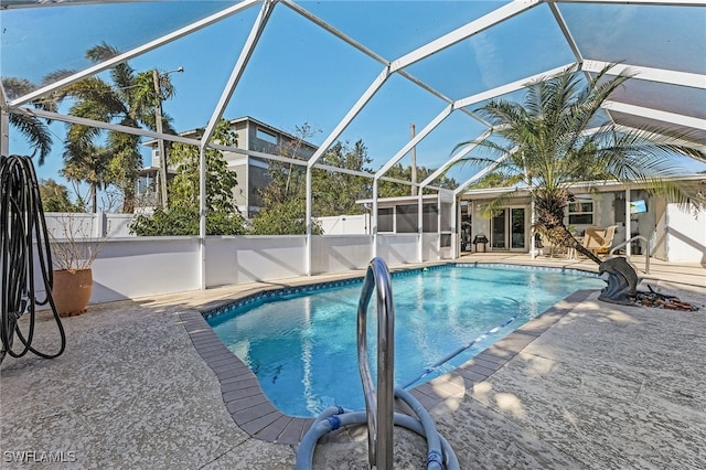 view of swimming pool featuring a lanai, fence, a fenced in pool, and a patio