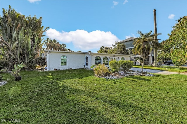 rear view of property with a yard and stucco siding