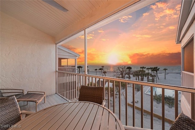 balcony with a water view and outdoor dining space