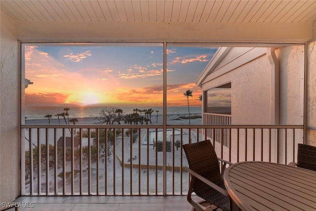 sunroom featuring wooden ceiling and a water view