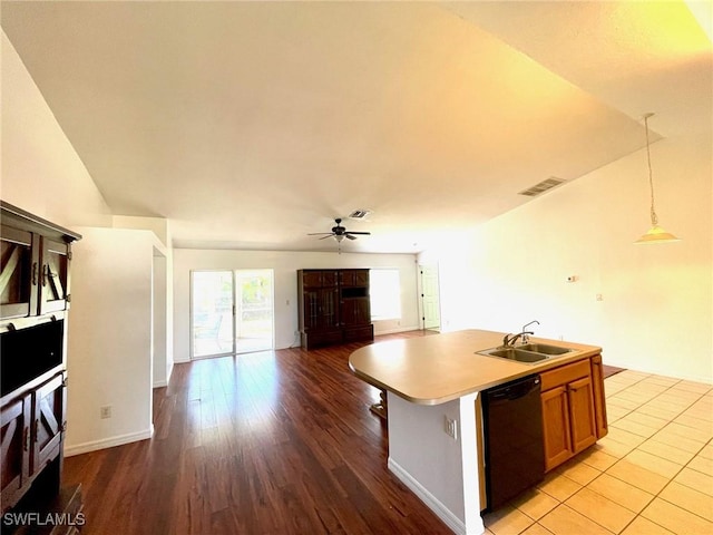 kitchen with a sink, visible vents, black dishwasher, light countertops, and open floor plan