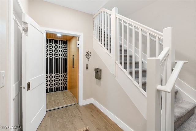 stairway with wood finish floors and baseboards