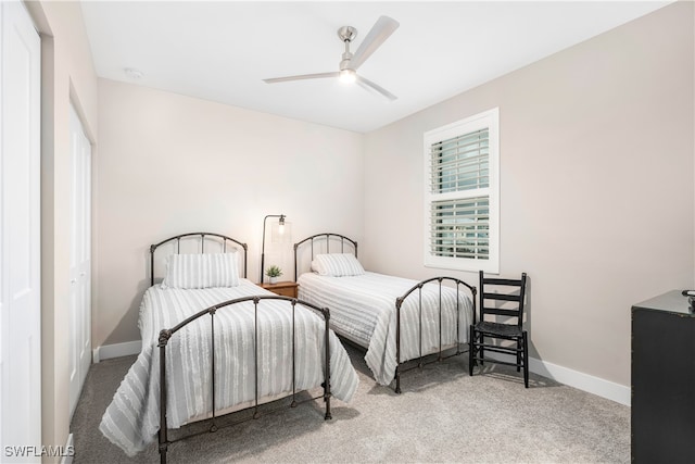 carpeted bedroom with ceiling fan and baseboards