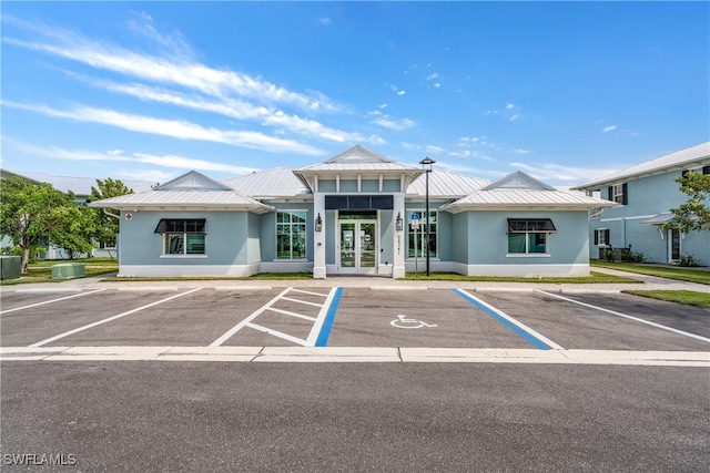 view of building exterior featuring uncovered parking and central AC unit