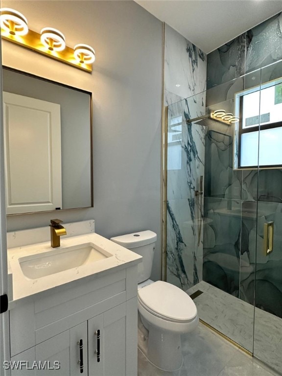 full bath with toilet, a marble finish shower, and vanity