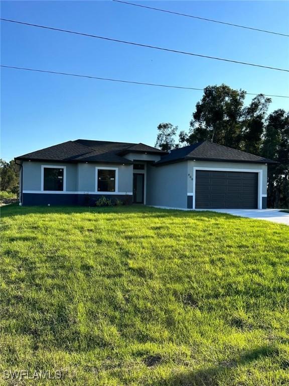 single story home featuring a garage, stucco siding, and a front yard