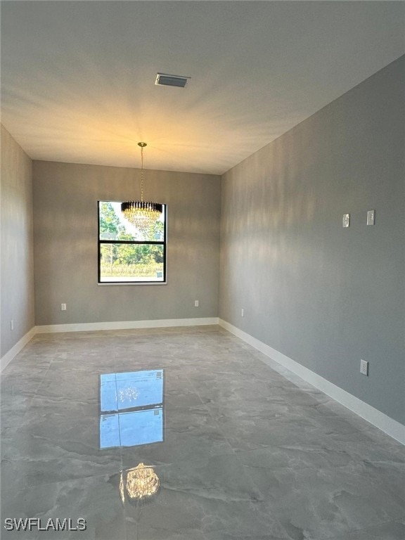 empty room with baseboards and visible vents