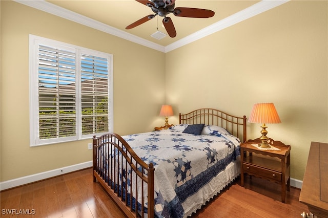 bedroom featuring ornamental molding, wood finished floors, a ceiling fan, and baseboards