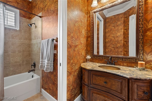 bathroom featuring baseboards, tub / shower combination, vanity, and wallpapered walls