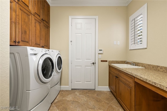 laundry room with cabinet space, baseboards, ornamental molding, washer and dryer, and a sink