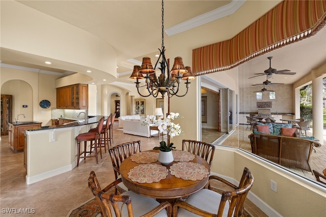 dining space with arched walkways, crown molding, recessed lighting, baseboards, and ceiling fan with notable chandelier