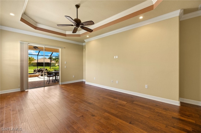 unfurnished room featuring baseboards, a sunroom, ornamental molding, dark wood-style flooring, and a tray ceiling