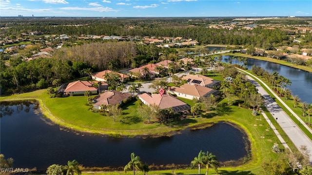 drone / aerial view featuring a residential view, a water view, and a forest view