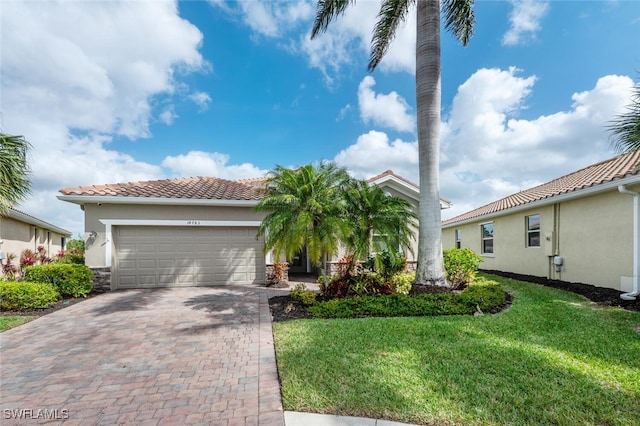 view of front facade featuring a front yard, decorative driveway, a tile roof, and stucco siding