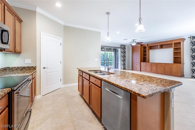 kitchen with a sink, stainless steel appliances, dark stone counters, brown cabinetry, and crown molding