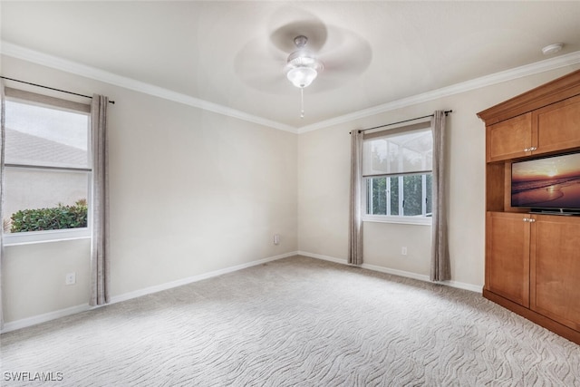 interior space with a ceiling fan, crown molding, baseboards, and carpet floors