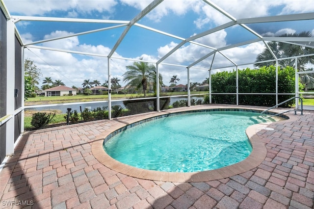 pool featuring glass enclosure, a water view, and a patio