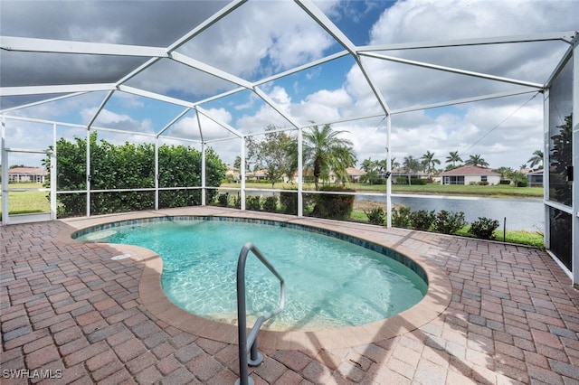 outdoor pool with a lanai, a patio area, and a water view