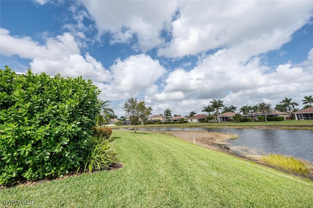 view of yard with a residential view and a water view