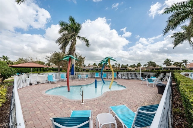 view of play area with a patio area, a community pool, and fence