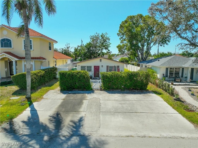 view of front of property with a fenced front yard, a tile roof, and stucco siding