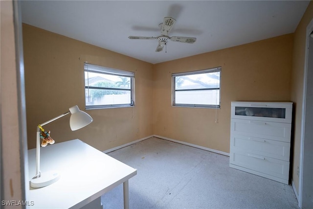 unfurnished office featuring baseboards and a ceiling fan