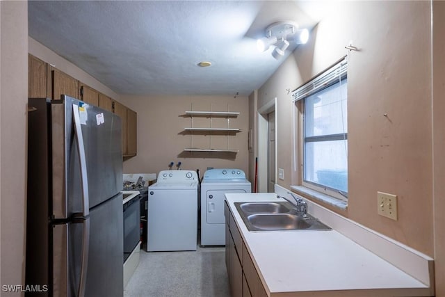 laundry room with laundry area, separate washer and dryer, and a sink