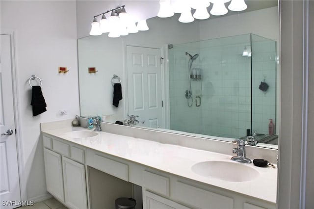 full bath with double vanity, a stall shower, and a sink