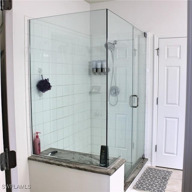 full bath featuring a shower stall and tile patterned floors