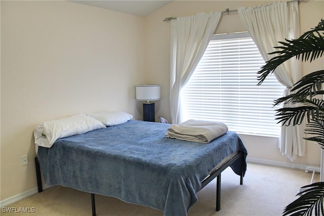 bedroom featuring carpet, vaulted ceiling, and baseboards