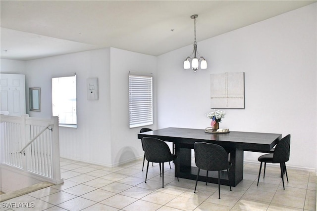 dining space with a chandelier, light tile patterned flooring, and baseboards