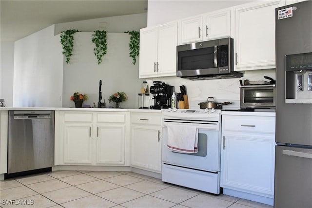 kitchen featuring light tile patterned flooring, a toaster, white cabinetry, appliances with stainless steel finishes, and backsplash